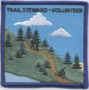 Trail steward volunteer patch with hill, trees, hikers, and mountain biker